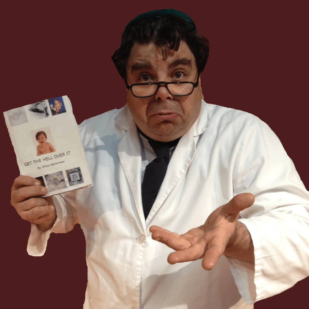 man with glasses gesturing towards camera holding a good that reads "get the hell over it"